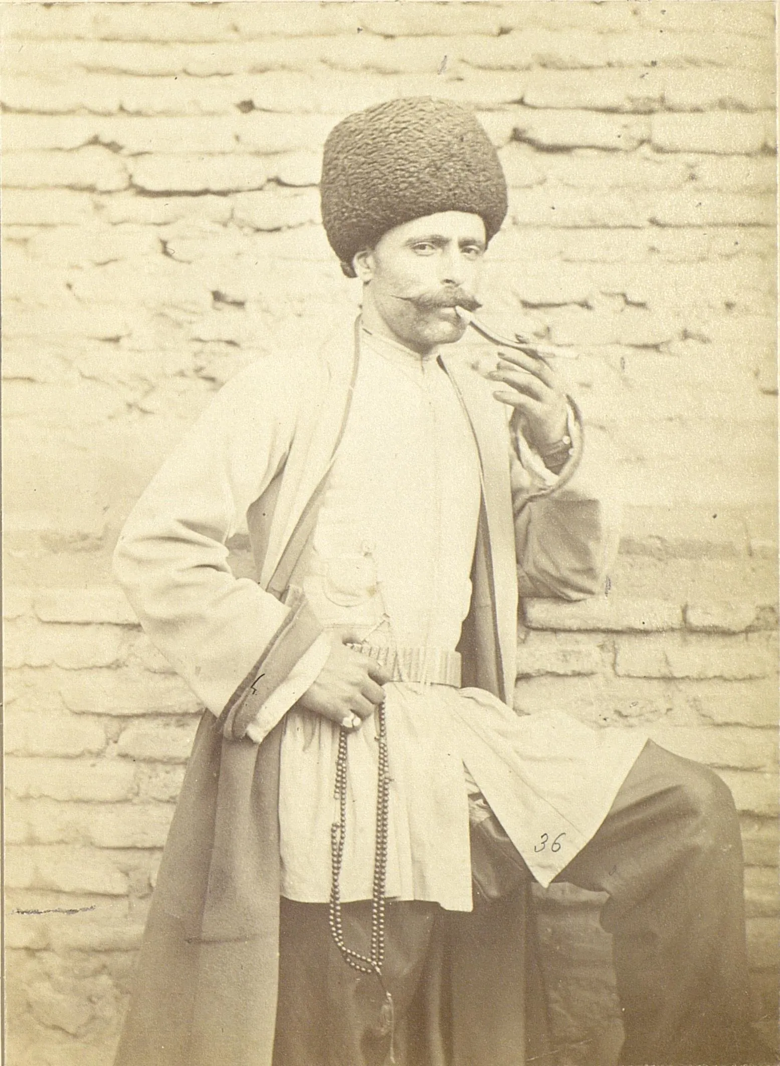 Azerbaijani man wearing Chepken, Koynek, Shalwar, and Papaq while proudly smoking his pipe.