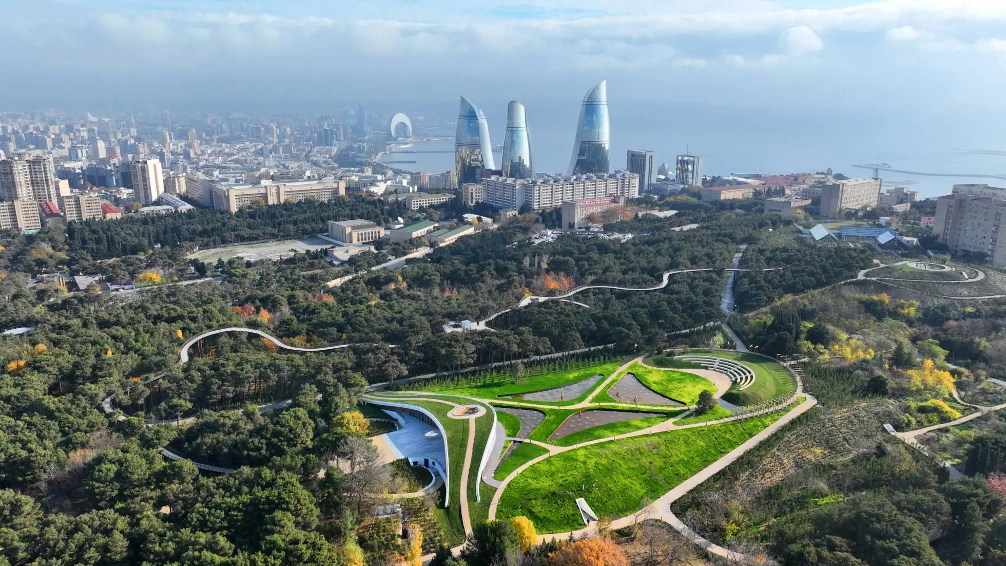 The bird’s-eye view of the Central Botanical Garden of Baku, the Caspian Sea, Flame Towers, and the city along Baku Bay.