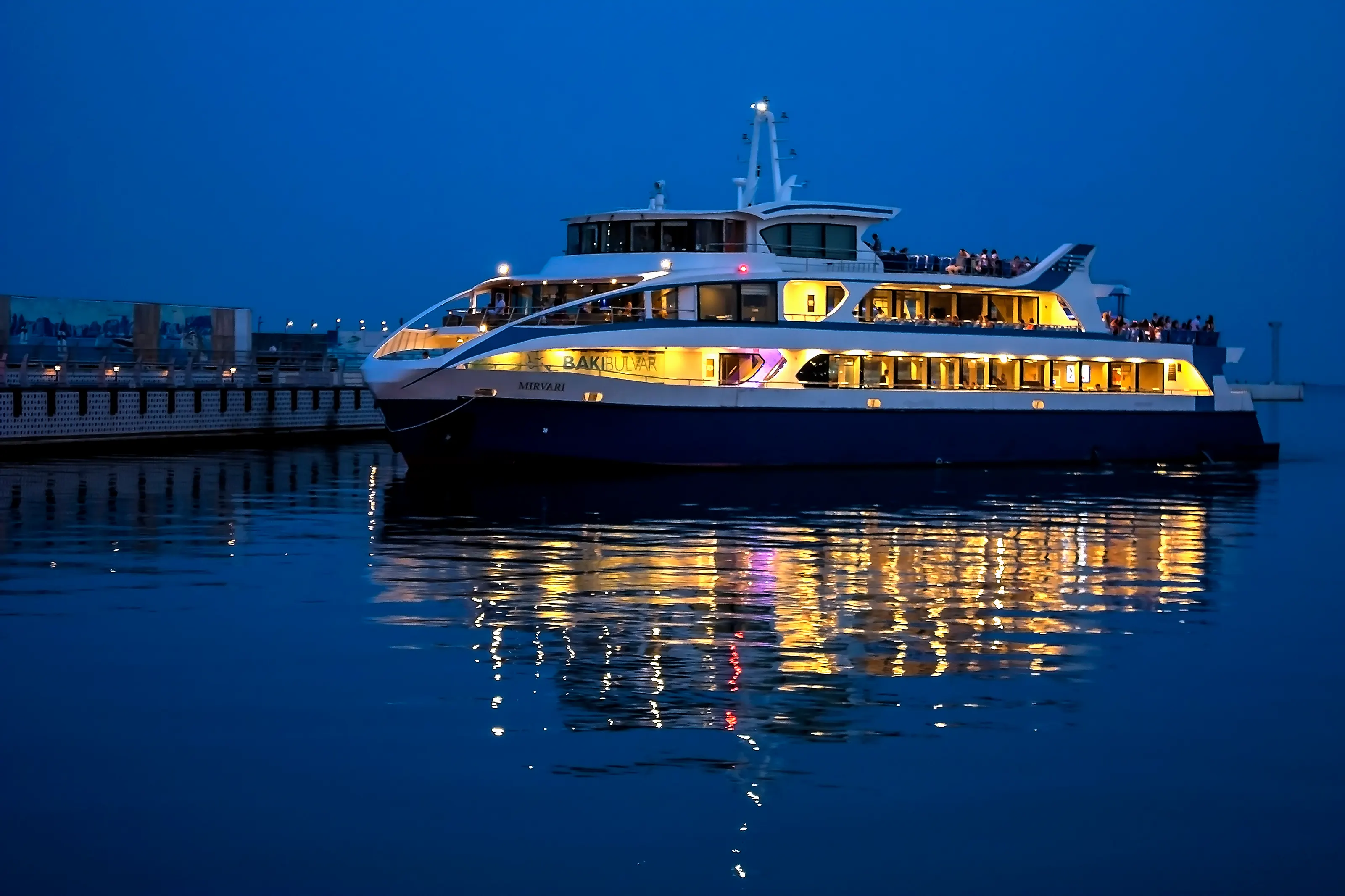Caspian cruise ship “Mirvari” at the pier at night with its dim lights.