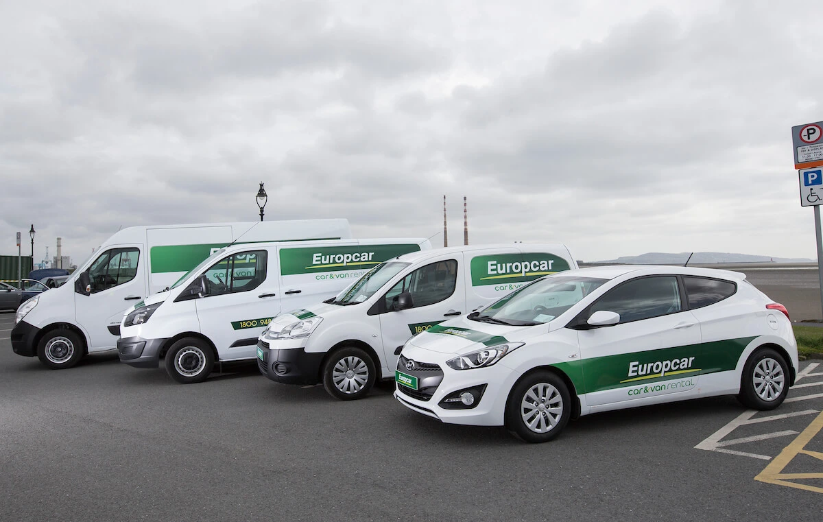 Diverse Europcar rental fleet, including sedan and vans in cloudy weather.