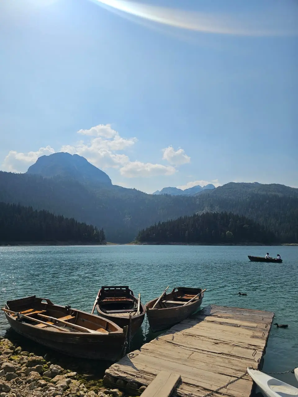 Wooden boats moored on Black Lake with mountains in the background.