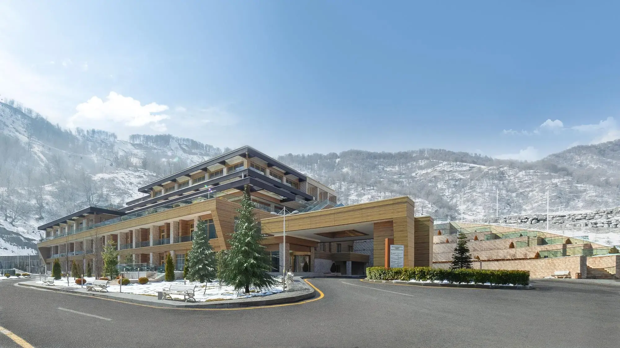 Qafqaz Tufandag Mountain Resort Hotel in winter, with slight snow on the ground.